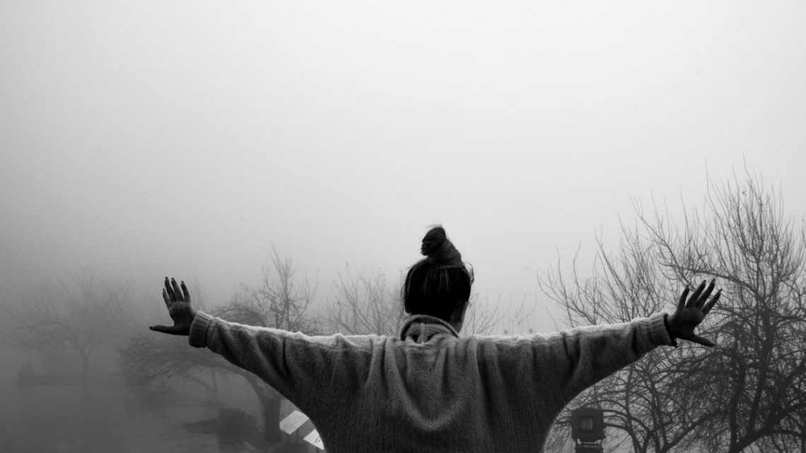a black and white photo of a man with a bird on his shoulders